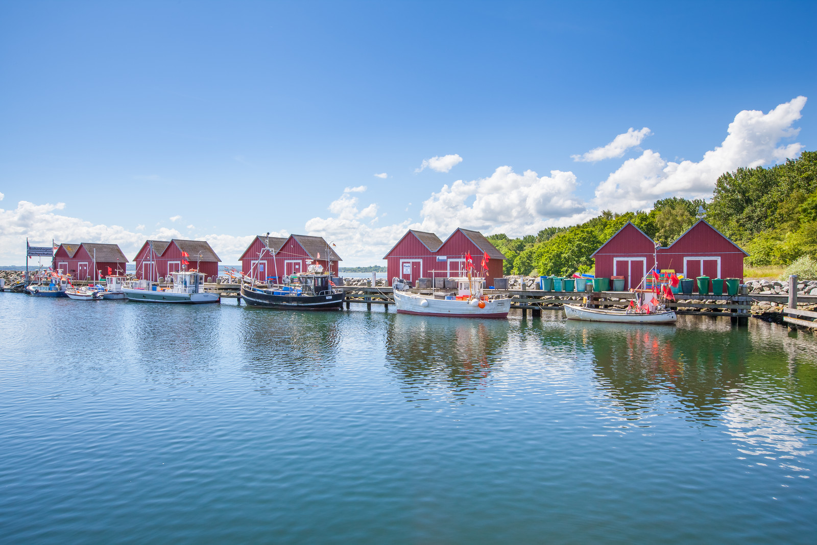 Fischereihafen von Boltenhagen mit roten Häusern auf einem Steg.
